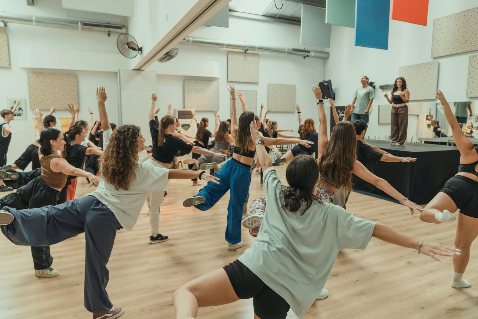 Energetic dance class with diverse participants practicing in a studio.